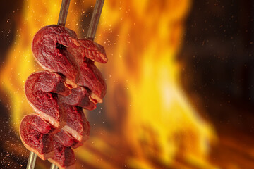 two raw picanha on skewer, traditional brazilian beef cut