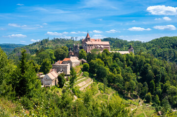 Outdoor view of Pernstejn castle near the Nedvedice village, Czech Republic. Fairytale castle on hill during summer day. Big stone walls and towers.