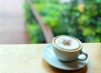 Hot cup of cappuccino coffee in garden with copy space