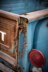 Rusty iron lock on wooden yellow rear gate of truck