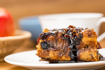 Extreme closeup a slice of homemade fruitcake poured with chocolate syrup.