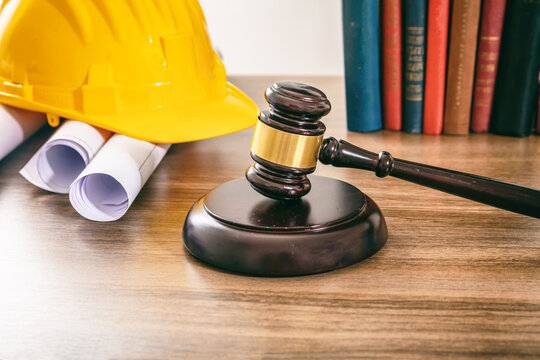 Construction and Labor law. Judge gavel and building drawings on table