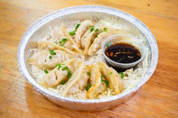 Asian Dumplings or Potstickers with soy sauce in Aluminium Foil Container.