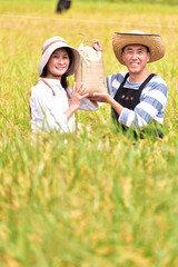 稲穂　収穫　実り　米袋　田園　シニア夫婦