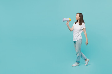 Full body side view young fun caucasian woman 20s she wear white t-shirt walk go hold scream in...