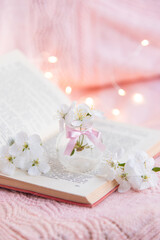 Open book with white small flowers on a pink background	