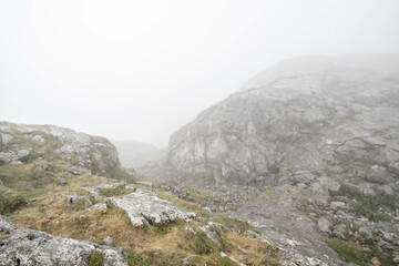 Fototapeta na wymiar Misty stoney road in foggy mountains