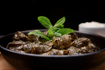 Dolma with sour cream and mint. Selective focus