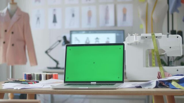 A Mock-Up Green Screen Laptop Is On The Table In The Designer Studio
