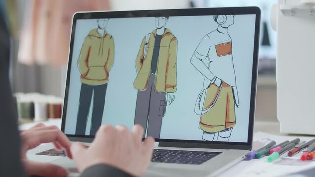 Close Up Of Female Designer'S Hands Designing Clothes On A Laptop In The Studio. Dress Production Procedure Concept. Cyber Games Clothing And Designing
