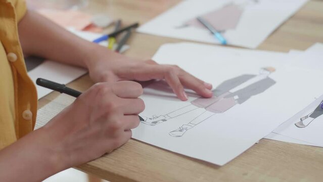 Close Up Of Female'S Hand Designing Clothes On The Paper In The Studio
