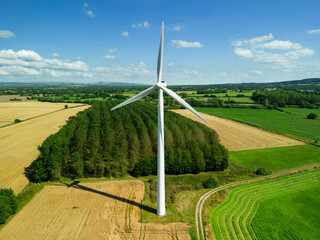 High level aspect aerial view of a wind turbine in a small rural wind farm in the English...