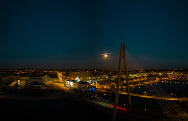 Fototapeta na wymiar Aerial view of the Millennium Bridge over Southport Marine Lake at night with moon rise, Southport Merseyside