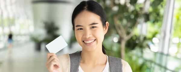 Header crop design of Asian female student holding blank credit card, concept of student card,...