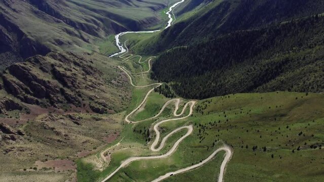 Teskey Torpock Pass (33 parrots) near to city Naryn and Son Kel lake in Kyrgyzstan. Epic slow movement from drone. Car ride on mountain road. 