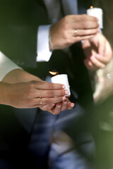 bride and groom holding candles in ceremony