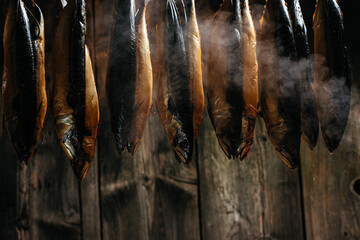 Smoked fish mackerel or scomber in smokehouse. Smoking Process Fish. banner, menu, recipe place for text