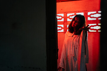 Ghost, zombie, demon A woman dressed up as a ghost in a bloody abandoned house for Halloween.