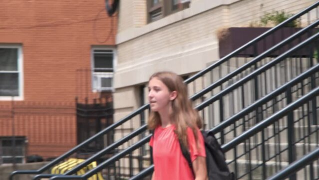 Girl in orange shirt with backpack walking on School Staircase - Slow Motion 