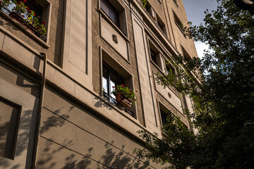 Building with windows and evening sun light and shadows. Sunset in the city Barcelona, Spain