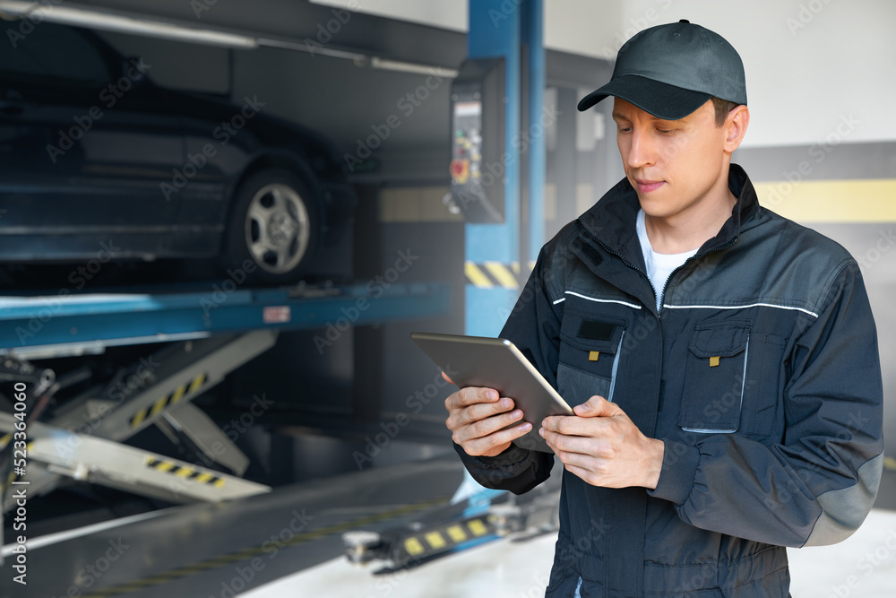 Aufkleber serviceman with digital tablet on a background of column lift at car service
