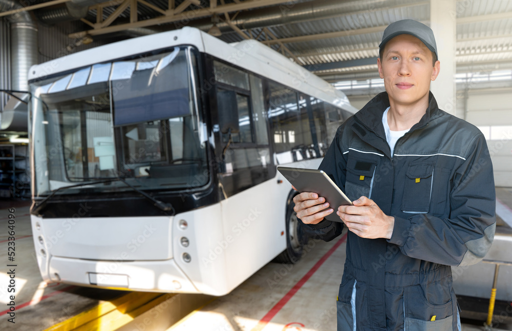 Aufkleber serviceman with digital tablet on the background of the bus in the garage