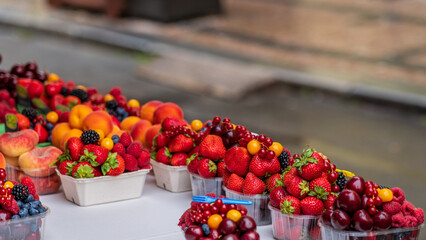 Boxes of red, yellow, black berries and fruit.
