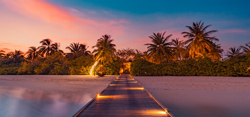 Amazing sunset panorama at Maldives. Luxury resort pier pathway, soft led lights into paradise island. Beautiful evening sky and colorful clouds. Romantic beach background for honeymoon vacation - obrazy, fototapety, plakaty