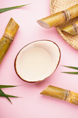 Fresh sugar cane juice and sugar cane on a pink background, vertically. Top view.