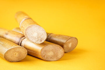 Sugarcane on a yellow background with space for text. Closeup.