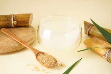 Fresh cane juice and brown sugar on a yellow background. Close-up.
