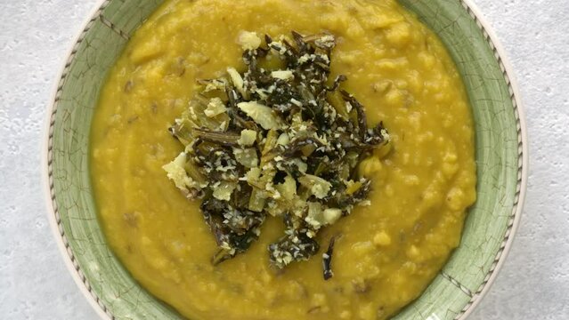 Toor dal with Sri Lankan type mallum (or mallung) made of chicory leaves and desiccated coconut. Close-up, table spin.