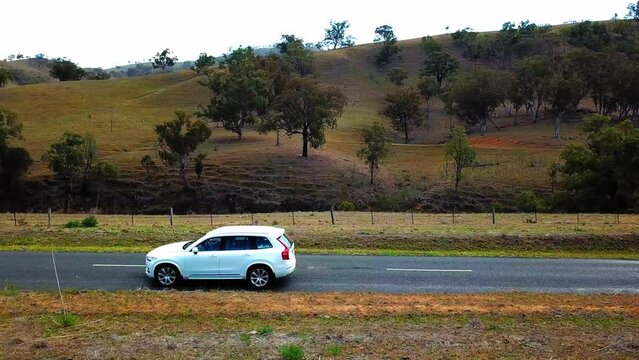 Panning Shot Of Person Driving White Car On Road By Natural Landscape - Brisbane, Australia