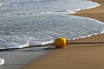 A rope with floats to secure a safe swimming area on the beach.