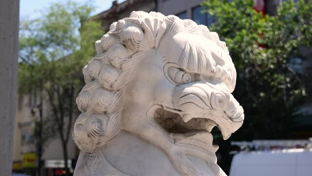 Zoomed in footage on the traditional Chinese guardian lion statue, aka shishi, on a street beneath the entrance gate to Chinatown in Montreal, Canada.