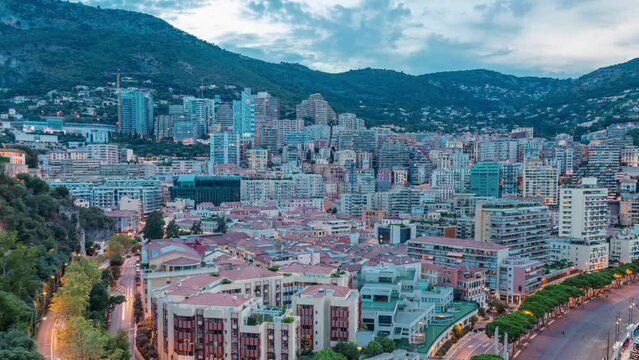 Panorama of Monte Carlo day to night transition timelapse from the observation deck in the village of Monaco near Port Hercules. Buildings with illumination and hills on background aerial top view