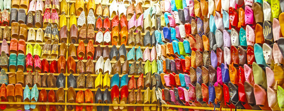 Store shelf with choice of many colorful typical oriental moroccan babouches leather slippers - Morocco