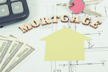 Inscription mortgage, dollar, keys and calculator on electrical drawing, calculations of buying or building house concept