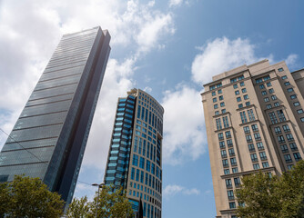 Modern tower buildings or skyscrapers in financial district with cloud on sunny day. bottom view