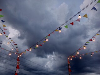 seen several colorful triangular flags hanging together with decorative lights under a cloudy sky