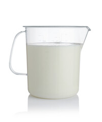 Milk in a plastic measuring cup isolated.