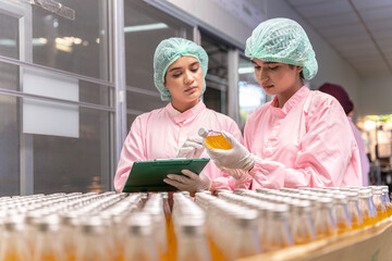 Indian engineers drink factory glass bottles Inspecting production fruit juice drinks that have...