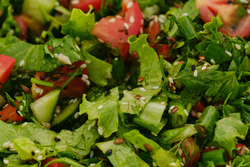 Concept of dietary nutrition and healthy lifestyle. Summer vegetarian salad of fresh vegetables tomatoes, cucumbers, lettuce and spices sesame and seeds. Minimalistic horizontal banner vegetables