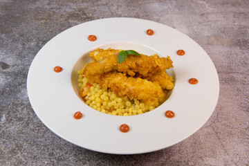 Recipe for chicken tenders with corn flakes and Italian Piombo pasta risotto and peppers. High quality photo