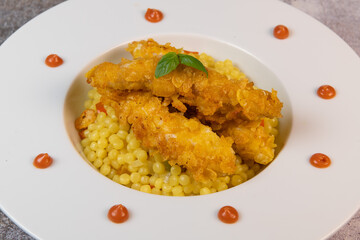 Recipe for chicken tenders with corn flakes and Italian Piombo pasta risotto and peppers. High quality photo