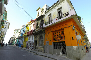 Street scene with classic old cars and traditional colorful buildings in downtown Havana