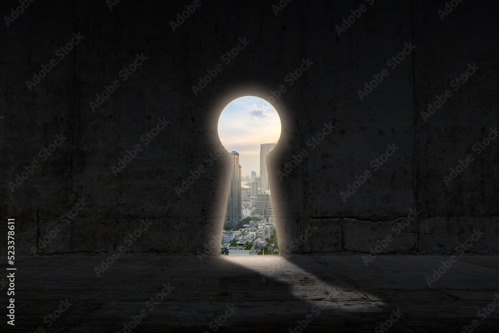 Wall mural opened keyhole concrete wall. cityscape view in the hole. key to success and career growth concept.