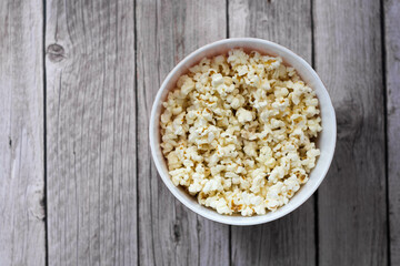 Bol de palomitas de maíz sobre mesa de madera.