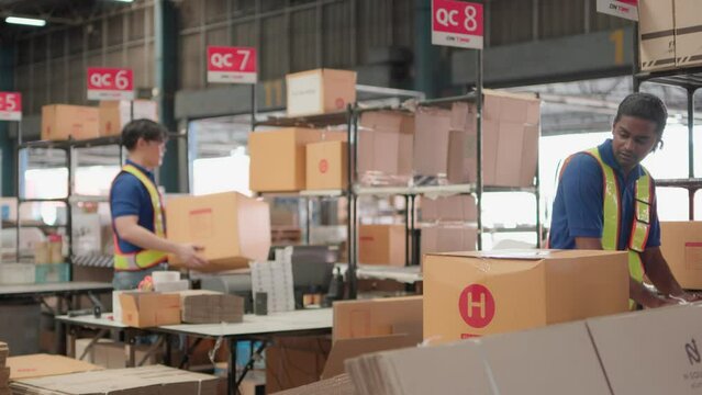 Two asian warehouse worker working checking package products in warehouse, logistic. While staff used laser barcode scanner on cardboard box, distribution center, placement in storage for shipping.