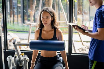 Young woman exercises on an exercise machine.